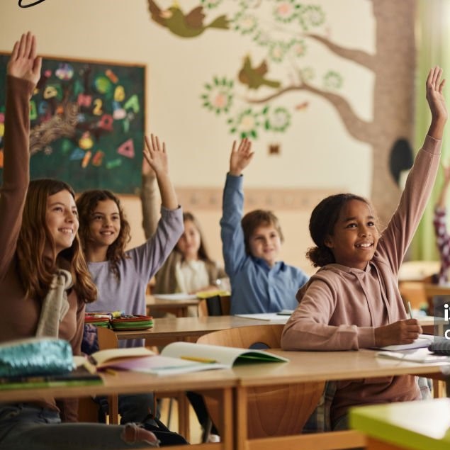 Large group of happy elementary students know the answer on a class in the classroom. Focus is on black girl.